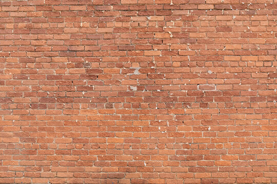 Background graphic resource brick wall with gaps in the pointing, heavily textured brick, horizontal aspect