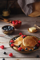 Pancakes with berries in rustic style