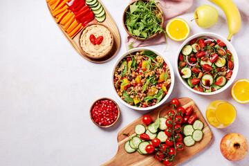 Fototapeta na wymiar Vegan or veganuary feast with various salads ad healthy plates on light gray table