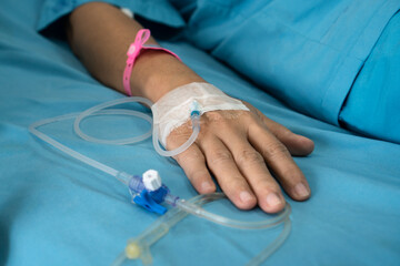 Patient woman hand with saline solution intravenous (IV) after surgery.