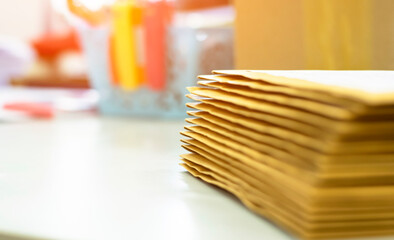 Soft focus on pile of brown envelopes on a desk for an office building bid opening, blurred background, concept checking achieves reports on busy work computer desk office.