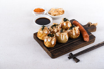 Takoyaki is Japanese Street Food containing with octopus, sausage or cheese. garnish with seaweed and katsuobushi
