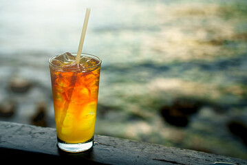 Glass of Mai Tai cocktail in front of the sea background.