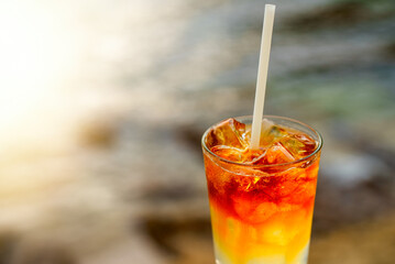 Glass of Mai Tai cocktail in front of the sea background.