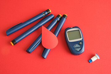 Diabetes concepta a device for measuring blood sugar, a paper drop of blood and syringe pens with...