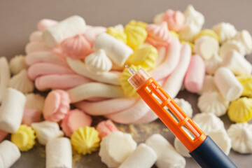 blood drop and meringue and marshmallows on red background, diabetes concept