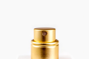 Golden perfume spray cap on light background close up with copy space.