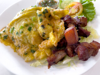 Steamed rice with omelette and fried pork belly put in white dish
