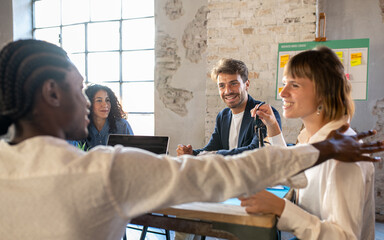 Young multiracial team of creative colleagues working in a open space, young smiling business man on focus,  teamwork of creative and fashion designer, brainstorming of happy people in office