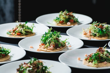 Set of spicy shrimp tacos with coleslaw and salsa served in a restaurant