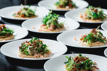 Set of spicy shrimp tacos with coleslaw and salsa served in a restaurant