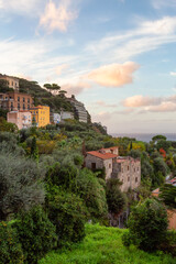 Fototapeta na wymiar Rocky Coast and Homes in Touristic Town, Sorrento, Italy. Amalfi Coast. Colorful Sunset Sky