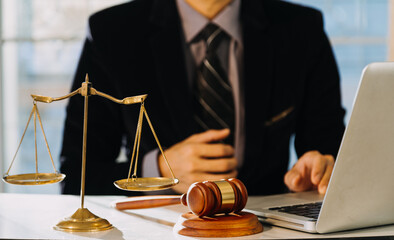 Business and lawyers discussing contract papers with brass scale on desk in office. Law, legal services, advice, justice and law concept.