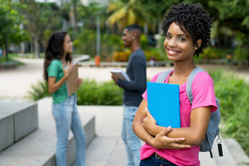 Happy brazilian female student with group of friends