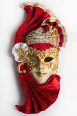 Traditional Venetian mask with red and gold decor isolated on white background. Mask for carnival of Venice.