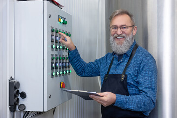 Mature bearded man controlling the working process at the factory