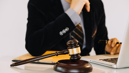 Business and lawyers discussing contract papers with brass scale on desk in office. Law, legal services, advice, justice and law concept.