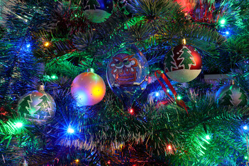 Christmas tree with decorations, fairy lights surrounded by many beautiful handmade painted colored balls for Christmas and new year celebration.