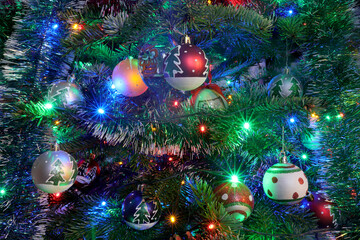 Christmas tree with decorations, fairy lights surrounded by many beautiful handmade painted colored balls for Christmas and new year celebration.