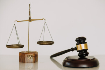 Business and lawyers discussing contract papers with brass scale on desk in office. Law, legal services, advice, justice and law concept.