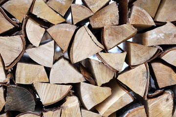 Fototapeta premium Chopped firewood in the woodpile. Stack of wood on winter street