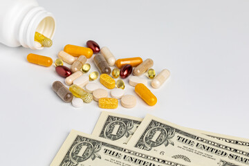 Pill bottle of vitamins and nutritional supplements with cash money isolated on white background. Wellness, health care and nutrition concept.