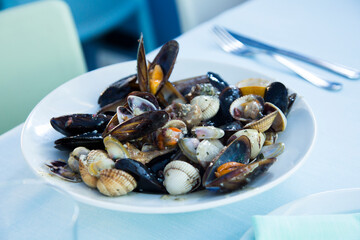 Dish with a variety of seafood such as mussels, clams and sea snails. Spanish fish tapa.