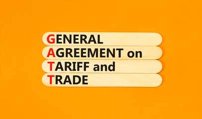 GATT symbol. Concept words GATT general agreement on tariff and trade on wooden stick on beautiful orange background. Business GATT general agreement on tariff and trade concept. Copy space.