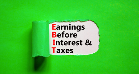 EBIT symbol. Concept words EBIT earnings before interest and taxes on white paper on beautiful green background. Business EBIT earnings before interest and taxes concept. Copy space.