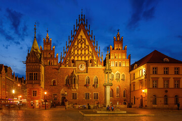Fototapeta na wymiar Wroclaw central market square with old houses, Town Hall and sunset, horse and carriage. Panoramic night view, long exposure.
