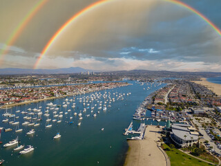 aerial shot of boats and yachts docked in the Newport Beach Harbor surrounded by blue ocean water,...