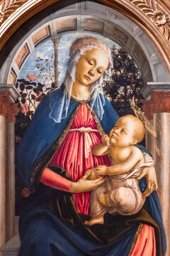 Close-up on medieval painting showing Virgin Mary under an arch holding baby Jesus