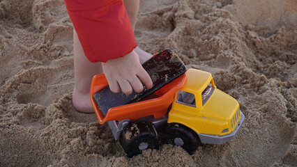 child placing a phone ensima of a toy car