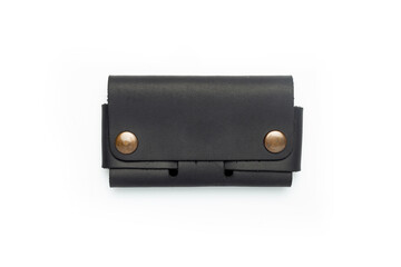 Naklejka premium Small black leather wallet on a button on a white background. Top view