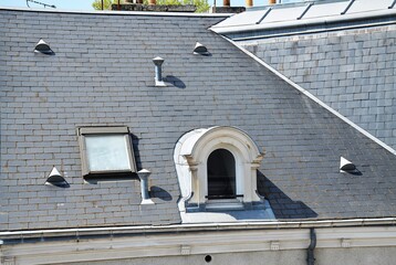 Slate roof with skylight, vasistas and zinc accessories: half-round cat flap, gutter, ventilation outlet cap, piece of roof. - obrazy, fototapety, plakaty