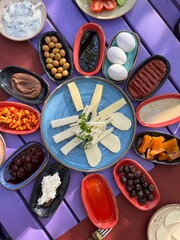 The famous Turkish breakfast, various plates, olives, cheese, eggs, jams, purple table, colourful