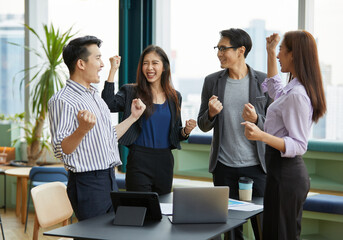 businesspeople raise arms up and celebrating success at work in the office