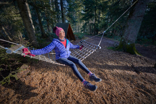 nice senior woman relaxing in a rustic hammock on a cold autumn day in the Allgaeu alps, Bavaria, Germany
