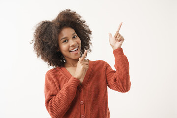 Portrait of African American young woman in red knitted sweater posing with smiling happiness face...