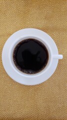 white cup of black coffee isolated on gold background