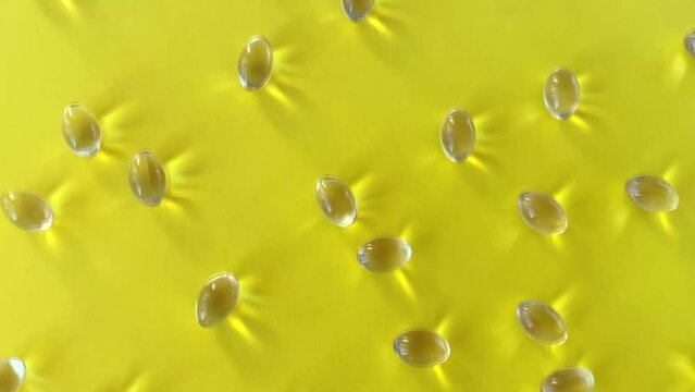 Vitamin D capsules Scattered on a yellow background in sunlight. The concept of health, good mood and the use of supplements