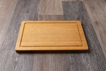 Empty cutting board on a wooden table, close-up, copy space for text.