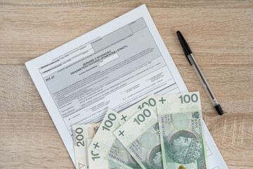 Blank PIT-37 income tax form and Polish złoty money, PLN zloty banknotes. Annual tax return...