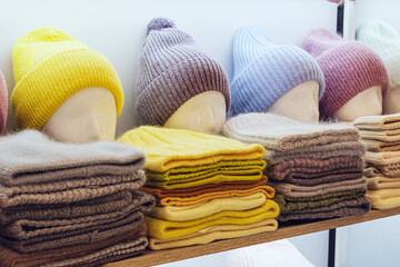 Showcase of trade tent with variety of women's hats for the autumn and winter seasons - knitted...