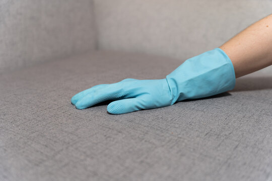 Kobieta w gumowej rękawiczce czyści wersalkę lifehack zbliżenie