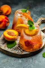 Refreshing summer homemade non-alcoholic cocktails, drinks peach cocktail with ice cubes, and mint in glass. Freeze motion splash drops