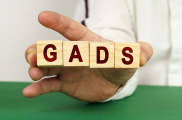 In the man's hand are cubes with the inscription - GADS