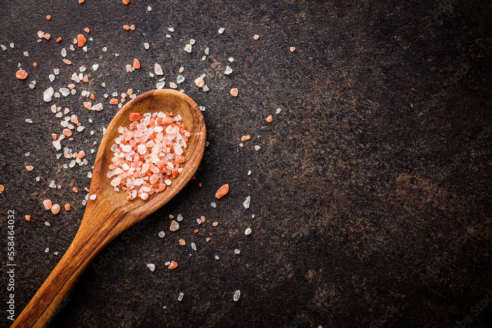 Wall mural pink himalayan salt in wooden spoon. top view.