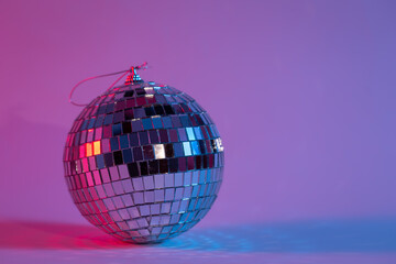 Disco ball in neon lighting isolated, concept of party, disco and dancing, copy space.