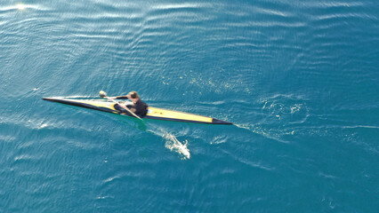 Aerial drone abstract slow shutter photo of athletes competing in sport canoe in tropical exotic...